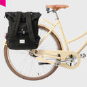 Schwarzes WEATHERGOODS SWEDEN Bikepack als Fahrradtasche am Gepäckträger eines cremefarbenen Retro-Fahrrads befestigt