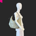 CROMIA ALYSON Beuteltasche olivgrau aus Leder – getragen als Schultertasche am Modell
