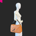 Cromia Alyson Schultertasche aus Leder in Cognac, handgetragen am Modell zur Darstellung der Größe