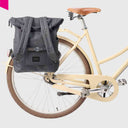 Dunkelblaues City Bikepack montiert an einem cremefarbenen Fahrradgepäckträger; idealer Mix aus intelligenter Funktionalität und Stil.