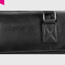 „Detailaufnahme der schwarzen Leder-Handtasche mit Logo-Prägung und stabiler Henkelbefestigung“
