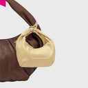 Greta Nano Silky als Taschenanhaenger an brauner Tasche befestigt
