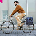 Radpendler in der Stadt mit dem dunkelblauen WEATHERGOODS SWEDEN City Bikepack als praktische Gepäckträgertasche am Fahrrad.
