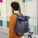 Rückansicht des dunkelblauen City Bikepacks von WEATHERGOODS SWEDEN, getragen als moderner Business-Rucksack im urbanen Umfeld.