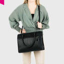 „Schwarze Leder-Handtasche mit abnehmbarem Schultergurt – getragen über der Schulter“