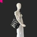 Schwarzer Shopper mit Flecht Optik am Model seitlich getragen
